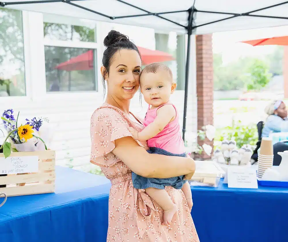 A mum holding her baby at the Market at Gianna table